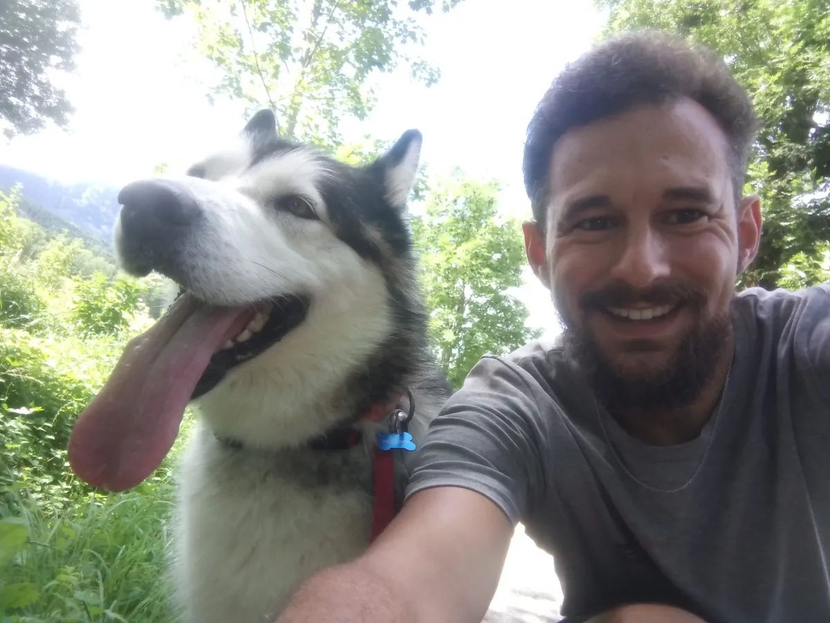 Un pet-sitter avec un grand chien noir et blanc