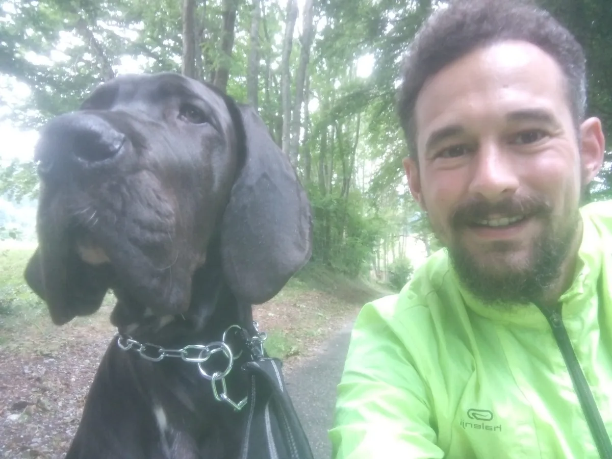 Un pet-sitter avec un grand chien noir en laisse
